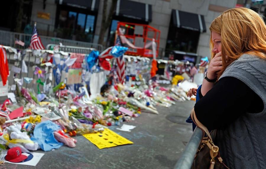 A woman looks over the memorial on Boylston Street Monday, April 22, 2013, in memory of the victims from the Boston Marathon bombing in Boston, Massachusetts. (Nancy Lane/Boston Herald/MCT)