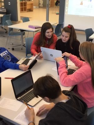 SHS junior Hannah Sylvester works with  7th graders, including her sister Lily, on their historical narrative writing project