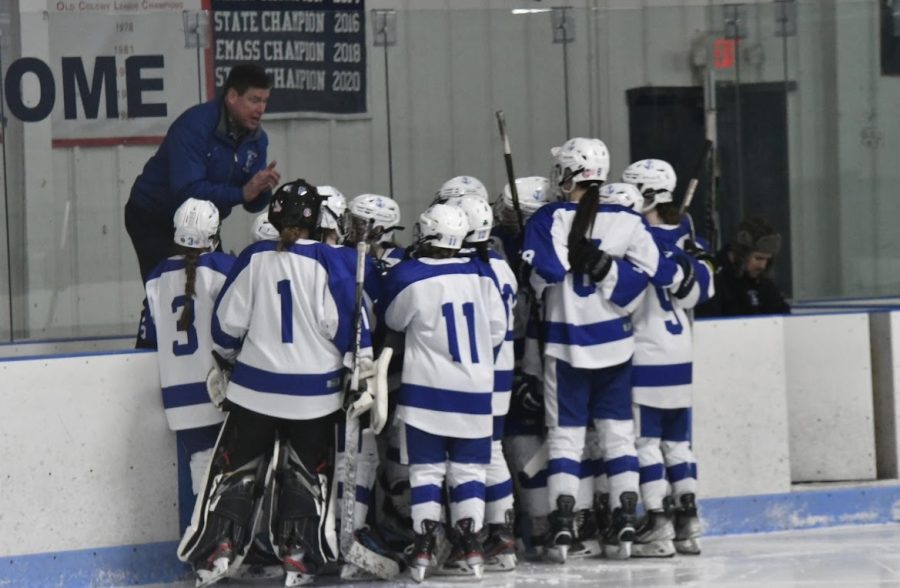 The girls' varsity hockey team receives a pre-game pep talk from Coach Thompson