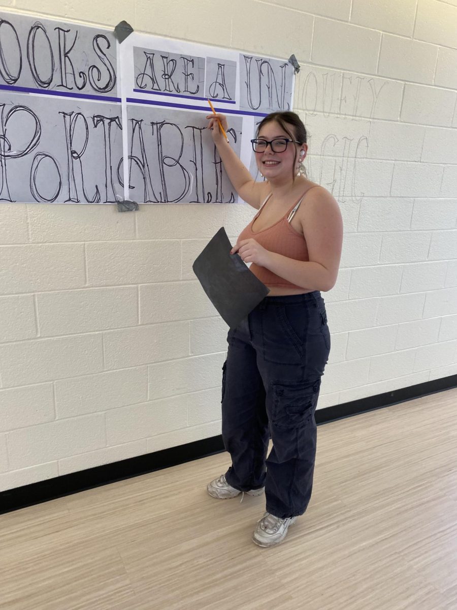 SHS junior Allison McGourty prepares a mural in the English hallway for Kindness Week