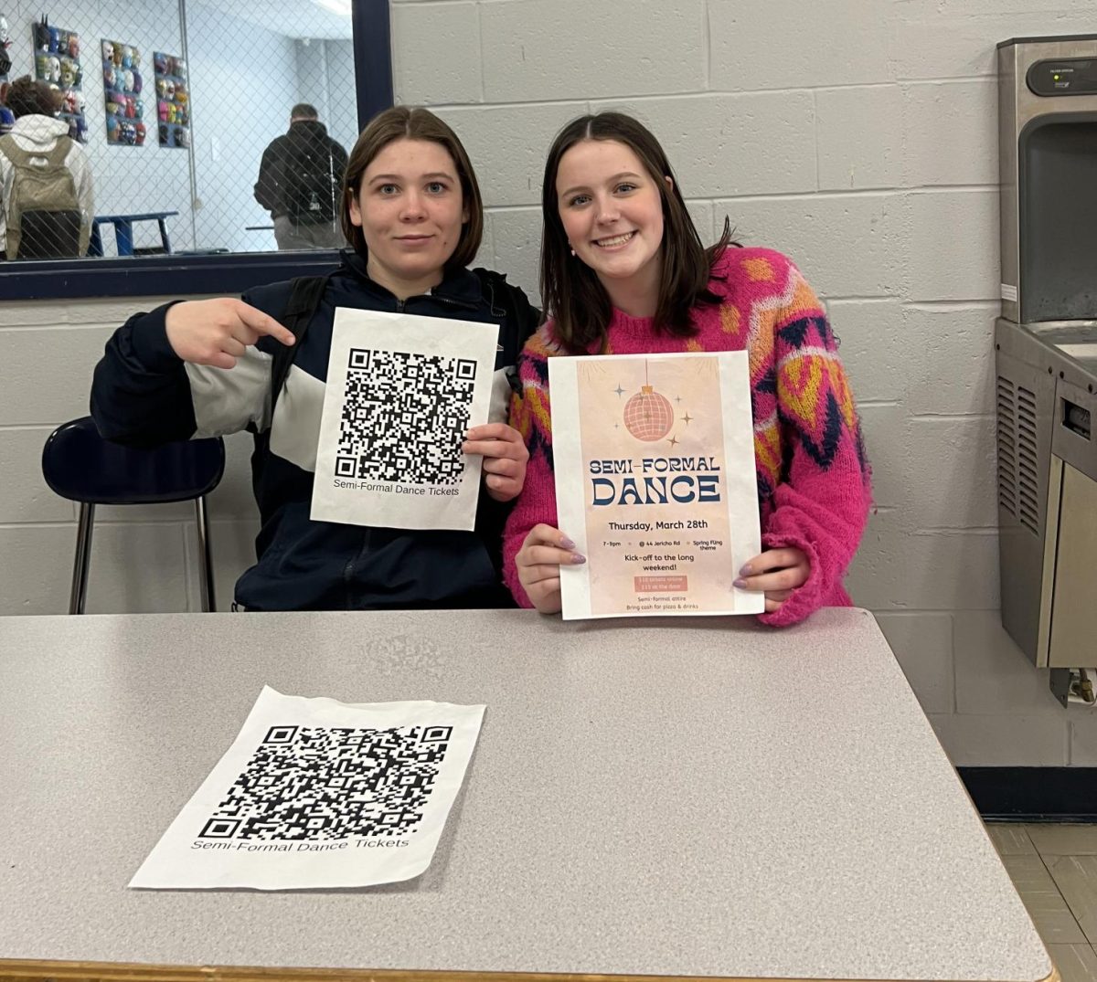 Sophomore Riley Guterl (left) and class president Nora Finkle (right) promote the semi-formal dance during lunch